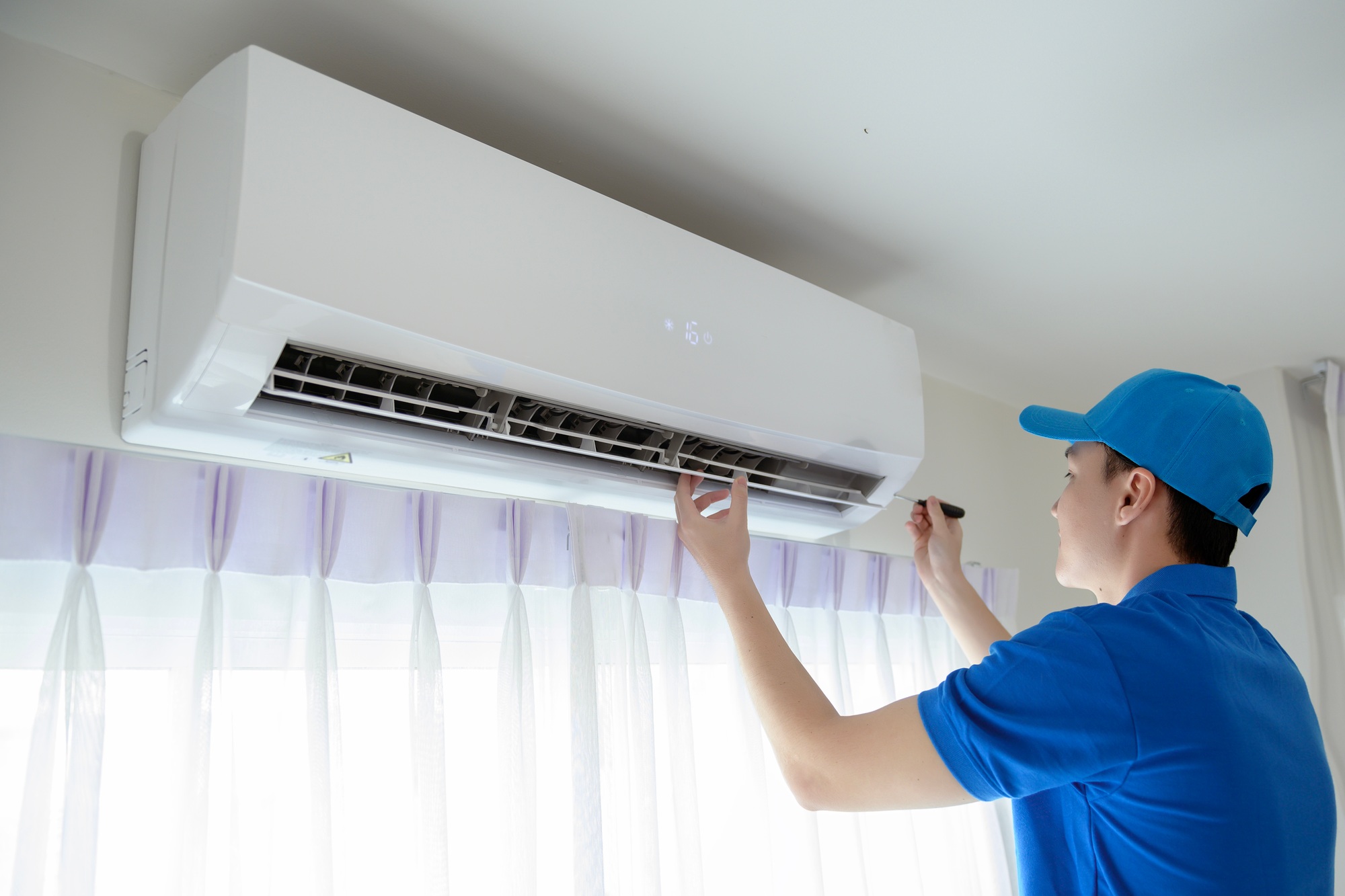 Technician service man checking air conditioner